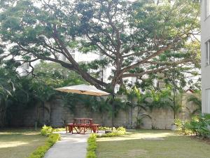 una mesa de picnic bajo un árbol con un paraguas en Conjunto Campestre 10min Centro Eventos Valle del Pacifico, Aeropuerto en Yumbo