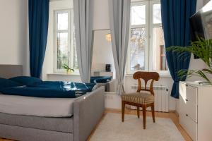 a bedroom with a bed and a chair and windows at Home Suites Home in Vienna