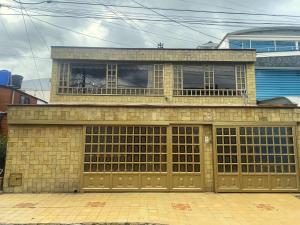 a brick building with two garage doors in front at Hospedaje Casa Dorada - Modelia in Bogotá