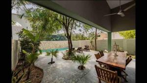 een patio met een tafel en stoelen en een zwembad bij Casa Cuatro Vientos in Tulum