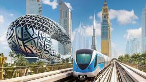 un treno bianco e blu sui binari di una città di Fashion Partition Room Near Mall of The Emirates a Dubai