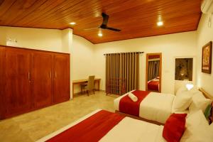 a large bedroom with a bed and a desk in it at Thisath Villa in Gonapinuwala West