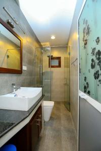 a bathroom with a sink and a shower and a toilet at Thisath Villa in Gonapinuwala West