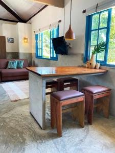 a living room with a large wooden table and stools at Santo Hostel in Porto Seguro