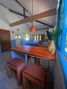 a dining room with a wooden table and a couch at Santo Hostel in Porto Seguro
