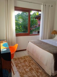 um quarto com uma cama e uma janela em Flat Sol do Ipanema em Itacaré