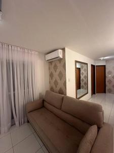 uma sala de estar com um sofá e um espelho em Apt Real em Paulo Afonso