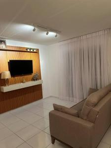 salon z kanapą i telewizorem w obiekcie Apt Real w mieście Paulo Afonso