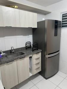 La cuisine est équipée d'un réfrigérateur en acier inoxydable et d'un évier. dans l'établissement Apt Real, à Paulo Afonso