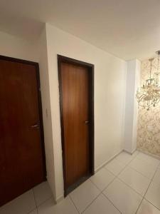korytarz z dwoma drewnianymi drzwiami w pokoju w obiekcie Apt Real w mieście Paulo Afonso