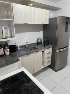 Apt Real في Paulo Afonso: مطبخ مع حوض وثلاجة حديد قابل للصدأ