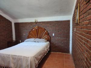 Habitación de ladrillo con cama en una pared de ladrillo en Casa Galaa Guiba', en Tangolunda