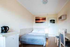 a small bedroom with a bed and a table at Rajska Mierzeja , SAUNA , JAKUZZI ,BASEN Z PODGRZEWANĄ WODĄ , KLIMATYZACJA-OGRZEWANIE , PLAC ZABAW , ROWERY , TARAS in Sarbinowo