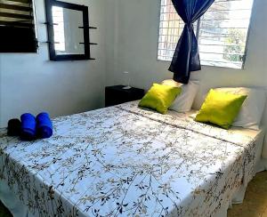 a bedroom with a bed with blue and yellow pillows at COSTA AZUL Apartment in La Libertad