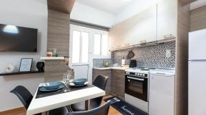 uma cozinha com electrodomésticos brancos e uma mesa com cadeiras em Aelia Apartment em Artemida