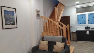 a living room with a staircase and a couch at Apartamento con encanto "ZIRIMIRI" in Bermeo