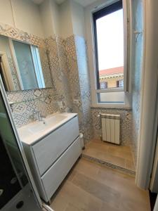 uma casa de banho com um lavatório branco e uma janela em Arie Romane Guesthouse em Roma