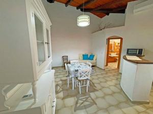 una cucina e una sala da pranzo con tavolo e sedie di Villa La Rosa dei Venti a Codaruina
