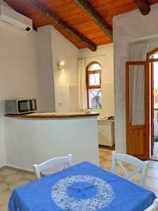 een keuken met een tafel met een blauwe tafeldoek erop bij Villa La Rosa dei Venti in Codaruina