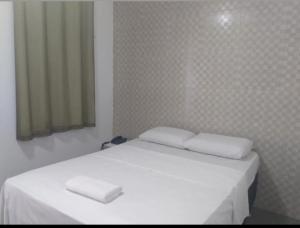 Una cama blanca con dos almohadas encima. en Pousada do Forte Recife, en Recife