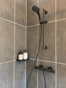 a shower with a blow dryer in a bathroom at Hygge-Apartment Jena in Jena +8 photos