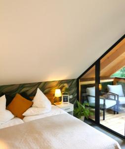 een slaapkamer met een groot bed en een balkon bij DAS Chalet mit Schlossblick in Wernigerode in Wernigerode