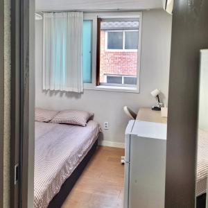 Un dormitorio pequeño con una cama y una ventana. en King's Garden, en Seúl 25 fotos más