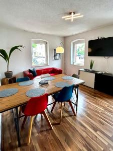 a living room with a large wooden table and chairs at OhPardon! GAILDORF - Monteurwohnung im EG, Einzelbetten, Loggia & Garten in Gaildorf
