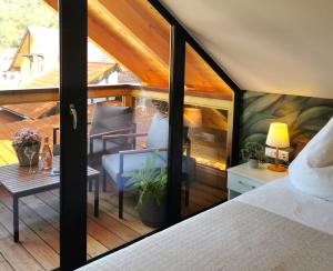 Habitación con balcón, cama y mesa. en DAS Chalet mit Schlossblick in Wernigerode, en Wernigerode