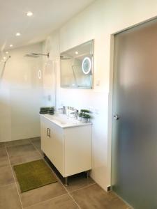 ein Bad mit einem Waschbecken und einem Spiegel in der Unterkunft DAS Chalet mit Schlossblick in Wernigerode in Wernigerode