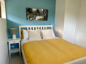 a bedroom with a bed with a yellow blanket at NEW - Sunny Coolum Beach Retreat in Coolum Beach