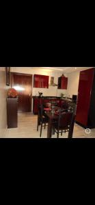 een keuken met rode kasten en een tafel en stoelen bij Cosy appartement only family à Gueliz in Marrakesh