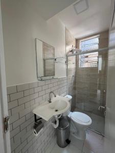 Baño blanco con lavabo y aseo en Casa de Mainha - Vila Mariana - unidade 2 en São Paulo