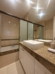 uma casa de banho com um lavatório branco e um espelho. em Apartamento aconchegante. no Rio de Janeiro