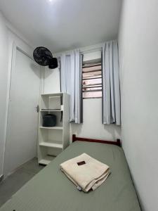 a bedroom with a bed with a towel on it at Casa de Mainha - Vila Mariana - unidade 2 in Sao Paulo