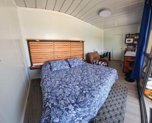 um quarto com uma cama com um edredão azul em Monteverde Numu em Monteverde