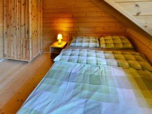 a bedroom with a bed in a wooden cabin at Holiday houses close to the beach, Siano ty in Sianozety