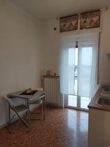 a kitchen with a table and a sink and a window at Appartamento Levante in Bari