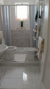 a white bathroom with a toilet and a sink at Appartamento Levante in Bari