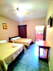 a hotel room with two beds and a table at Hotel Rosalila in Copan Ruinas