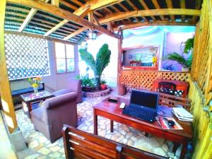 un soggiorno con scrivania e computer portatile. di Hotel Rosalila a Rovine di Copán