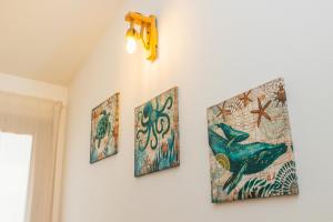 three pieces of art on a wall at Case Vacanze Il Sogno 2 in Porto Pino