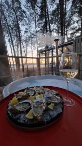 un plato de ostras y una copa de vino en una mesa en BOSE and Bang&Olufsen lofts on a lake by Gauja Club, en Gauja