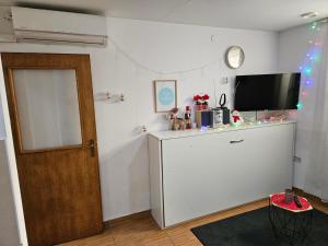 um quarto com um frigorífico, uma televisão e uma porta em Apartments Zagreb Center em Zagreb