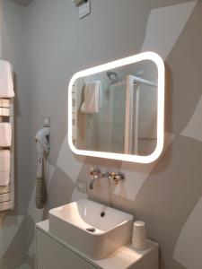 a white bathroom with a sink and a mirror at Piccolo Hotel Olina in Orta San Giulio