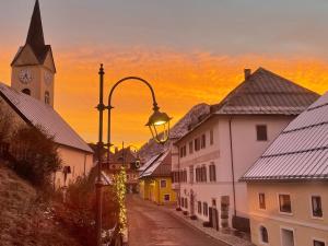 a city street with a clock tower and a street light at AFFITTACAMERE ALLE ALPI in Malborghetto Valbruna