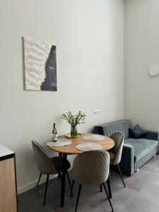 sala de estar con mesa, sillas y sofá en Albatross Loft en Ķesterciems