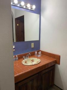 baño con lavabo y espejo grande en Los Barriles Hotel, en Los Barriles