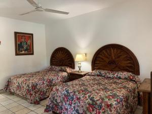 um quarto de hotel com 2 camas e uma ventoinha de tecto em Los Barriles Hotel em Los Barriles