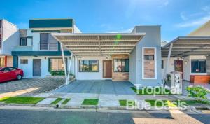 ein Haus mit einem davor geparkt in der Unterkunft Tropical Blue Oasis in Puntarenas